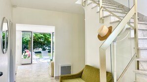 A modern interior with a staircase, a sofa, and a glass door leading outside.