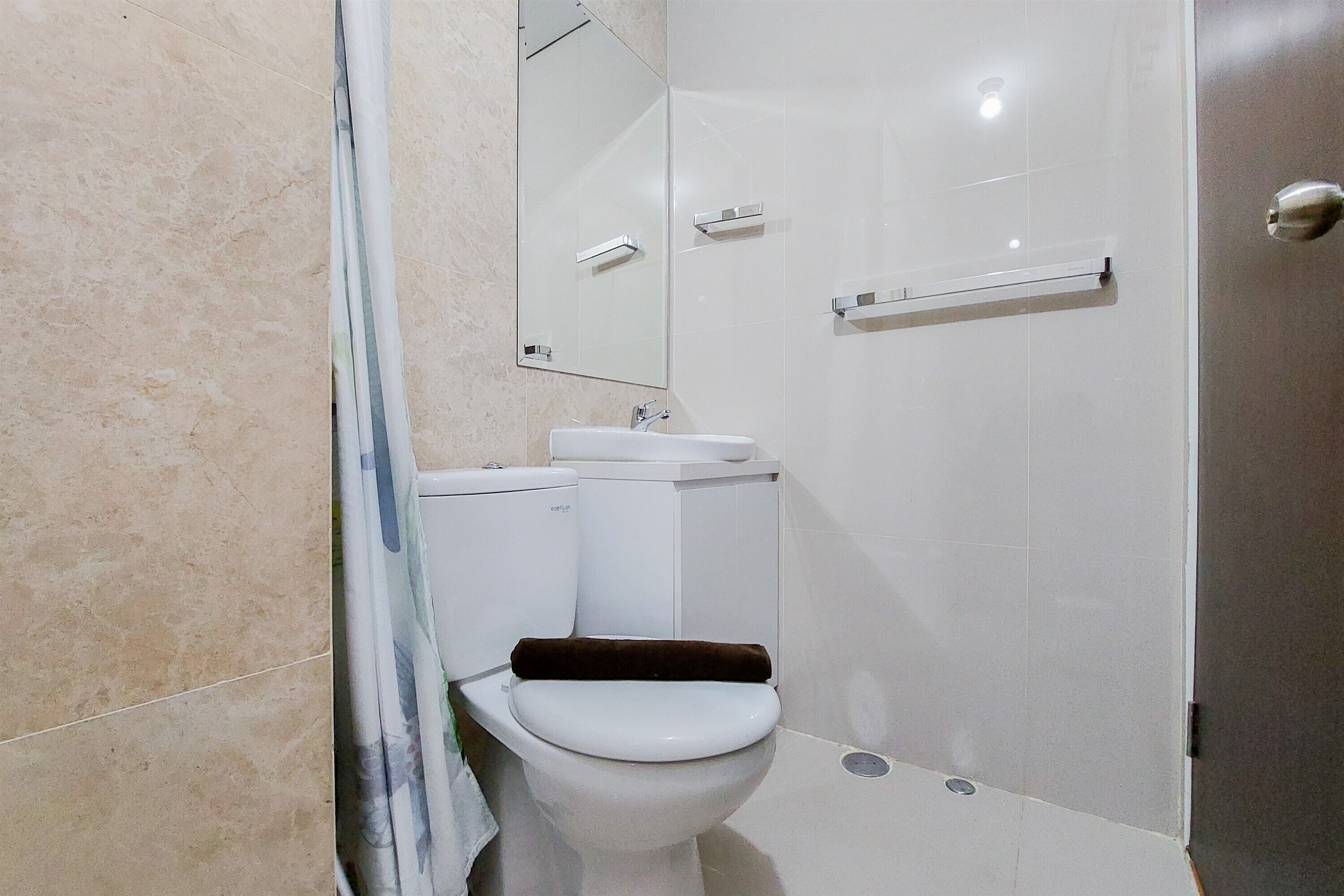 Een badkamer met toilet, wastafel en spiegel.