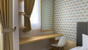 A room with a desk, a chair, a bed, and a window with curtains. - Cozy Nice Studio At Signature Park Grande Apartment (Jakarta)