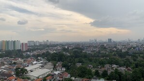 A cityscape with dense residential buildings, a prominent church, and high-rise buildings in the background. - Cozy Nice Studio At Signature Park Grande Apartment (Jakarta)