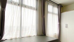 Una habitación con ventana, una banca y un armario.