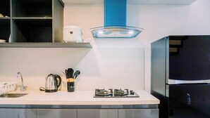 A modern kitchen with a stainless steel refrigerator, a gas stove, and a coffee maker.