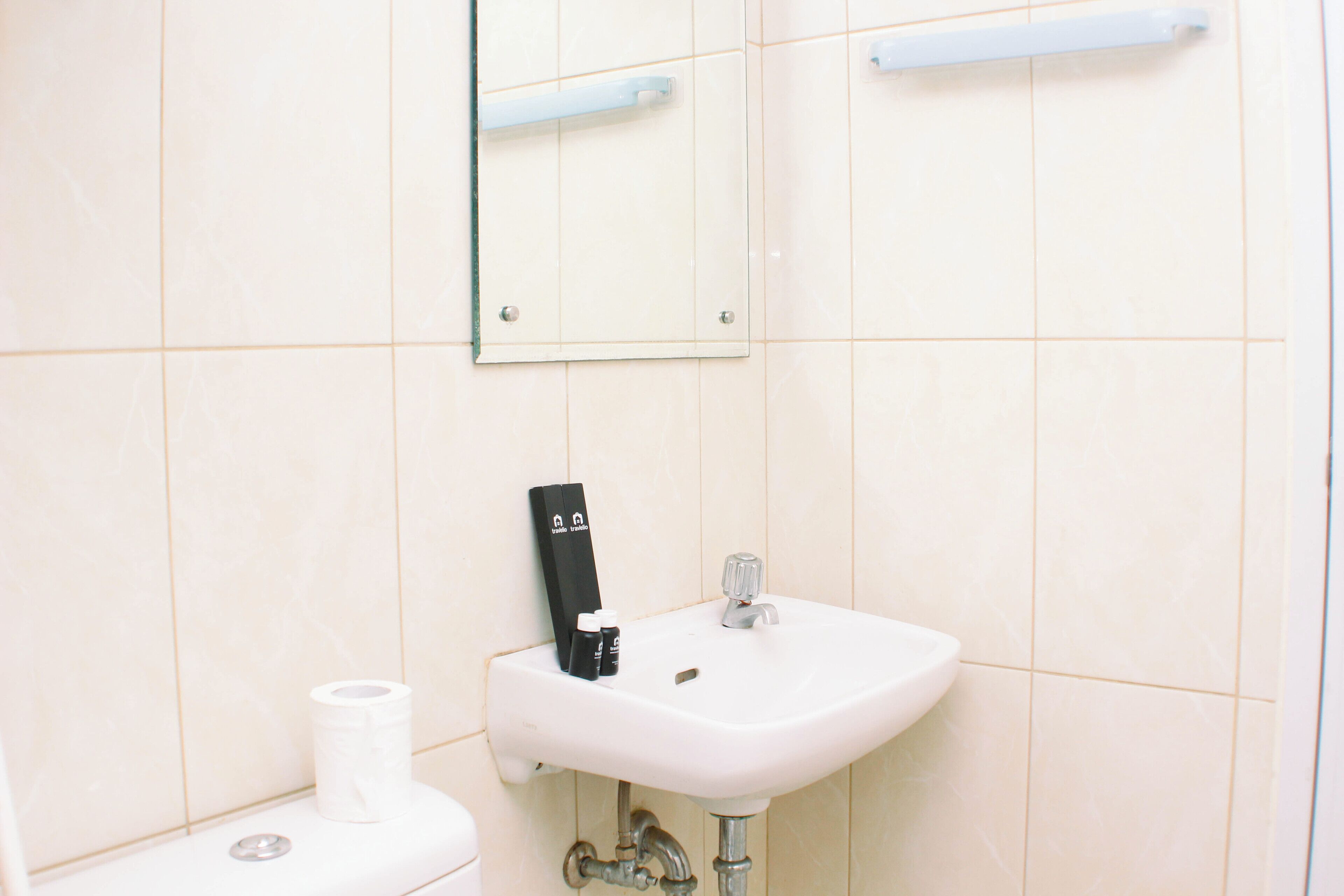 A bathroom with a white sink, a mirror, and a toilet.