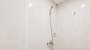 A shower with a handheld showerhead and a wall-mounted control panel. - Homey And Enjoy Living Studio Serpong Garden Apartment (Cisauk)