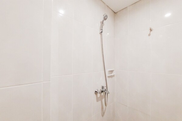 A shower with a handheld showerhead and a wall-mounted control panel. - Homey And Enjoy Living Studio Serpong Garden Apartment (Cisauk)