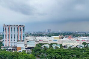 A high-rise hotel with multiple floors, surrounded by other buildings and greenery. - Comfortable And Nice 2Br At Springlake Summarecon Bekasi Apartment (Bekasi)