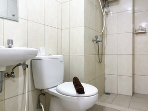 A bathroom with a toilet, a sink, and a shower. - Comfortable And Nice 2Br At Springlake Summarecon Bekasi Apartment (Bekasi)