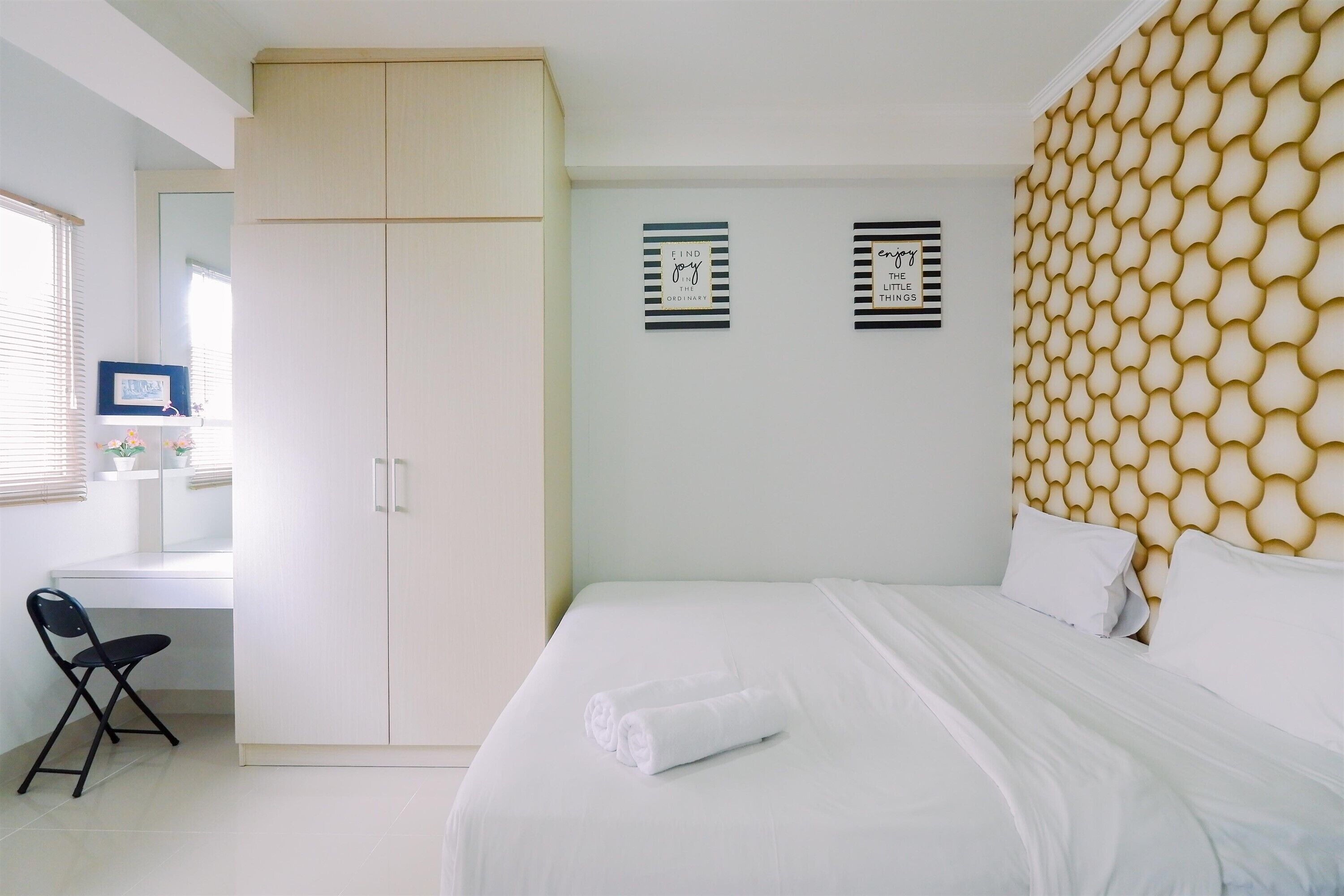 Un dormitorio con cama, escritorio y silla.
