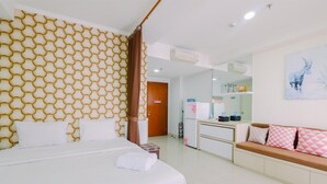 A hotel room with a bed, a sofa, a bathroom, and a kitchenette. - Best Choice And Restful Studio Signature Park Grande Apartment (Jakarta)