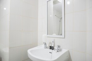 Deluxe studio | Badkamer | Een douche, handdoeken, zeep, shampoo