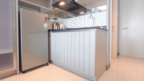 A kitchen with a refrigerator, a microwave, and a sink. - Beautiful And Modern Studio At Benson Supermall Mansion Apartment (Surabaya)