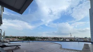 Una piscina en la azotea con vistas a un paisaje urbano.