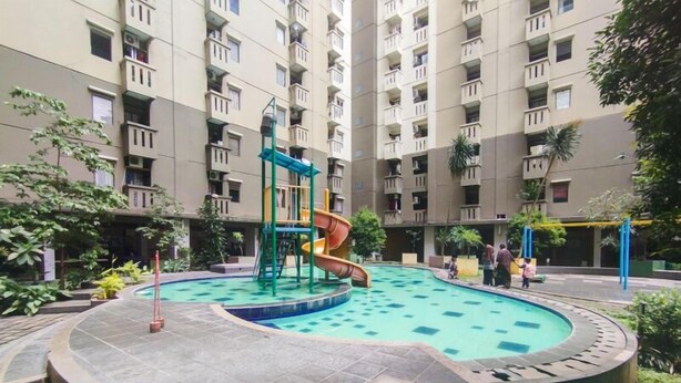 Un edificio residencial con piscina y zona de juegos infantiles.