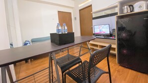 Una cocina moderna con refrigerador, microondas y televisor. Hay dos botellas de agua sobre una bandeja negra.