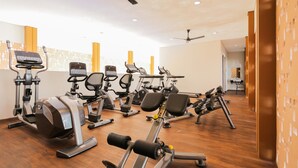 A modern gym with various exercise equipment, including treadmills, stationary bikes, and weight machines. - Good Place And Homey 3Br At Asatti Apartment (Pagedangan)