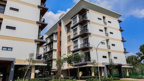 A multi-story residential building with balconies, air conditioning units, and a clear sky. - Good Place And Homey 3Br At Asatti Apartment (Pagedangan)