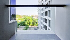 A narrow stairway leading to a balcony with a view of a building and greenery. - Good Place And Homey 2Br At Green Park Yogyakarta Apartment (Depok)