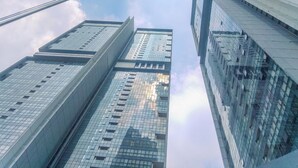 A tall, modern building with a glass facade and multiple floors. - Good Deal And Elegant Studio Ciputra World 2 Apartment (Jakarta)