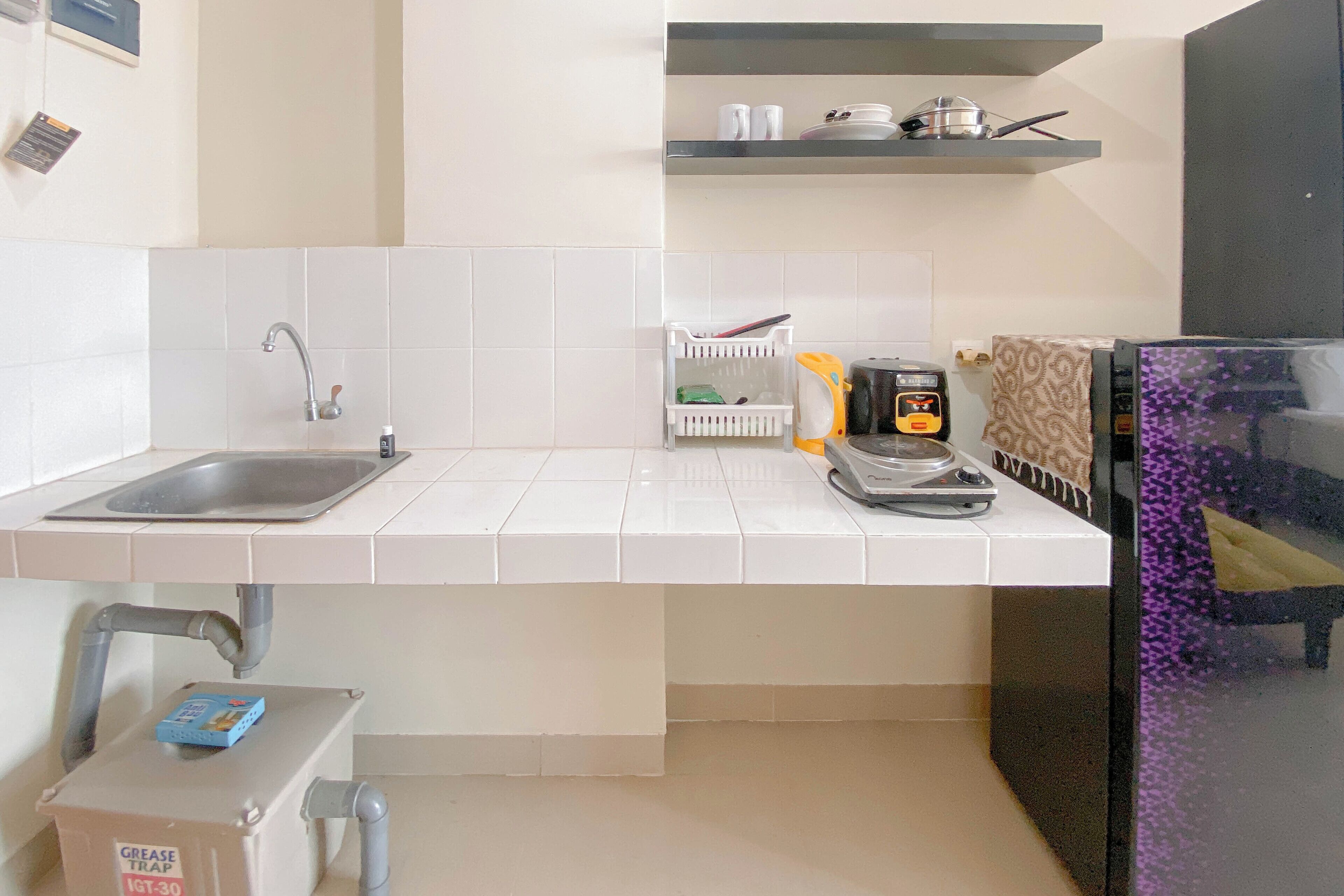 A kitchen with a sink, a gas stove, and a refrigerator.