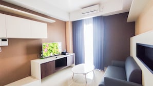 Una sala de estar moderna con una televisión de pantalla plana, un sofá, una mesa de centro y un mueble para el televisor.