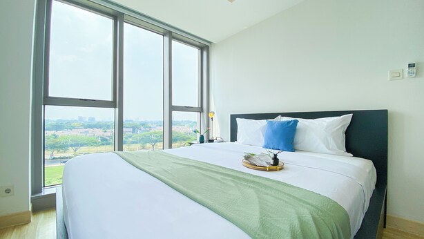 Ένα δωμάτιο ξενοδοχείου με ένα μεγάλο κρεβάτι, θέα στην πόλη και ένα παράθυρο με θέα στην εξοχή.