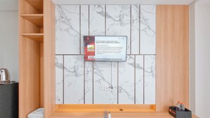 A modern bathroom with a marble backsplash, wooden shelves, and a built-in sink. - Relaxing And Cozy Studio Patraland Amarta Apartment (Ngaglik)