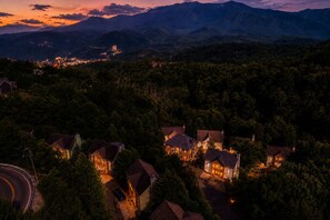 Un quartier résidentiel où les maisons sont entourées d’une forêt dense et où l’on aperçoit des montagnes au loin.