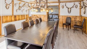 A long dining table with chairs, wooden paneling, and antler decorations on the walls. - Luxury Retreat With Amenities - By Traum Ferienwohnungen (Kjellerup)