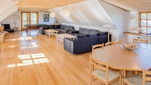 A spacious loft with a high ceiling, wooden floors, a dining area with a round table and chairs, a sofa set, and a billiards table. - Luxury Retreat With Amenities - By Traum Ferienwohnungen (Kjellerup)