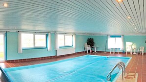 A large indoor swimming pool with a tiled floor and a ceiling with linear lighting fixtures. - Luxury Retreat With Amenities - By Traum Ferienwohnungen (Kjellerup)