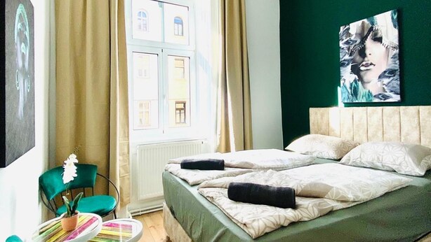Une chambre d’hôtel avec un lit, une chaise, une fenêtre et un tableau au mur.