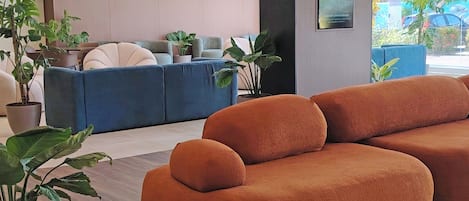 A modern interior with sofas and potted plants.