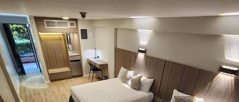 Ett hotellrum med två sängar, ett skrivbord och ett litet pentry.