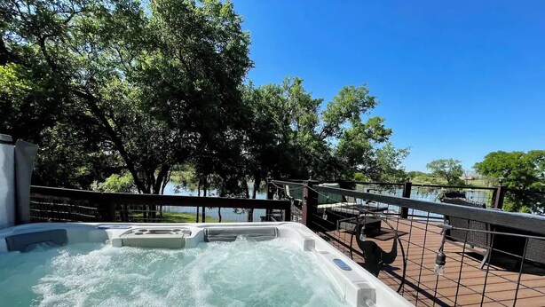A hot tub on a deck with a view of a lake and trees. - Peaceful Texas Ranch Retreat on the Lake (Midlothian)