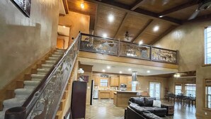 A spacious living area with a staircase, a kitchen, and a dining area. - Peaceful Texas Ranch Retreat on the Lake (Midlothian)