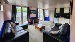 A modern living room with a sofa, a coffee table, and a TV mounted on the wall.