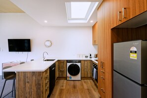 Una cucina moderna dotata di lavastoviglie, lavatrice e frigorifero.