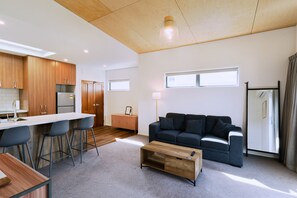 A modern apartment with a kitchen, dining area, and living room.