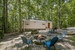 A cabin with a fire pit, outdoor seating, and a picnic table surrounded by trees. - Hidden Ridge Cabin | Big Pine Retreat, Trails (Rockbridge)