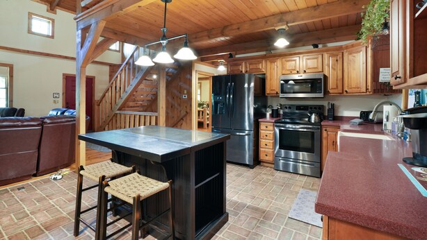 A spacious kitchen with wooden cabinets, a large island, and stainless steel appliances.