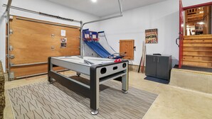 A pool table with a blue and red net, a wooden door, and a poster on the wall.