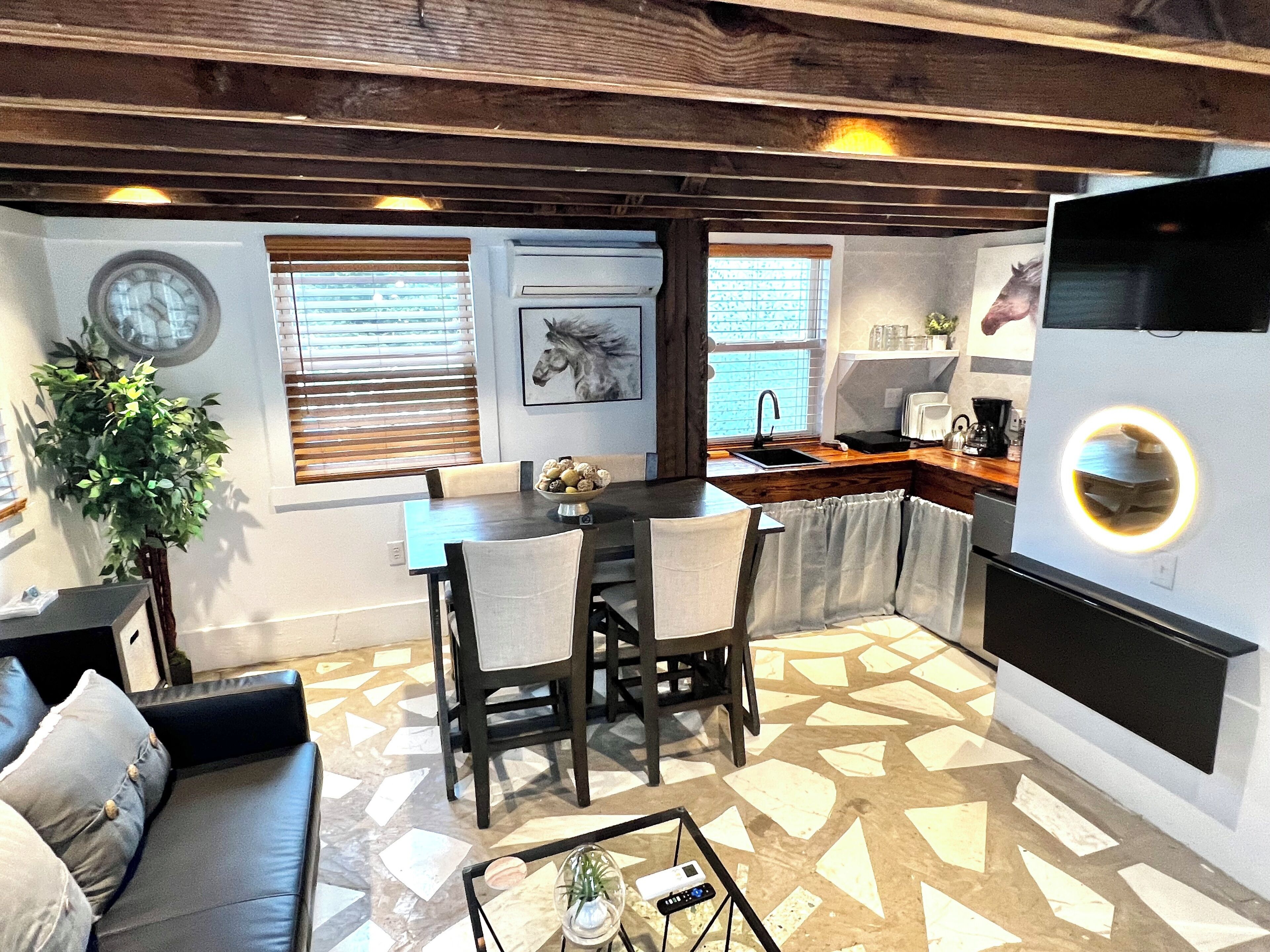 Un espace de vie compact comprenant un coin repas, une cuisine et un coin salon.