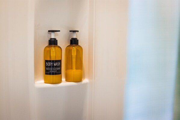 Two bottles of body wash in a bathroom.