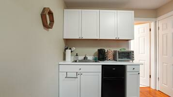 Coffee/tea maker, microwave, coffee grinder, dining table