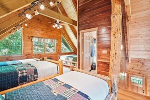 A cabin with two beds, a wooden ceiling, and a door leading outside. - Grizzly Ridge | Hocking Hills, Pool, Hot Tub (Logan)
