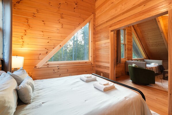 Une pièce de style cabane en bois, comprenant un lit, un bureau et une chaise.