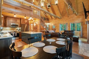 Interior espacioso de una cabaña de madera con cocina, comedor y sala de estar.