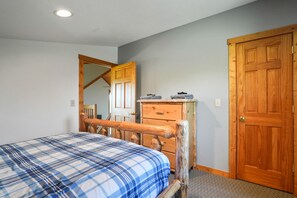 A bedroom with a bed, wooden dresser, and a door. - Hilltop Hideaway | Hocking Hills, 16 Acres (McArthur)
