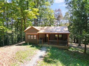 A small wooden cabin with a porch, surrounded by trees. - Ridge Point Cabin | Hocking Hills, Secluded (Rockbridge)