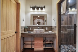A bathroom with a wooden vanity, a large mirror, and a shower area. - Ridge Point Cabin | Hocking Hills, Secluded (Rockbridge)
